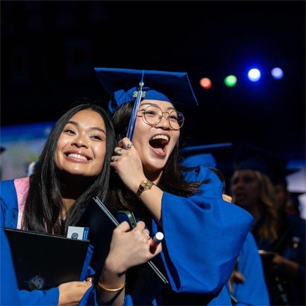 两名毕业生在获得文凭后露出喜悦的表情.